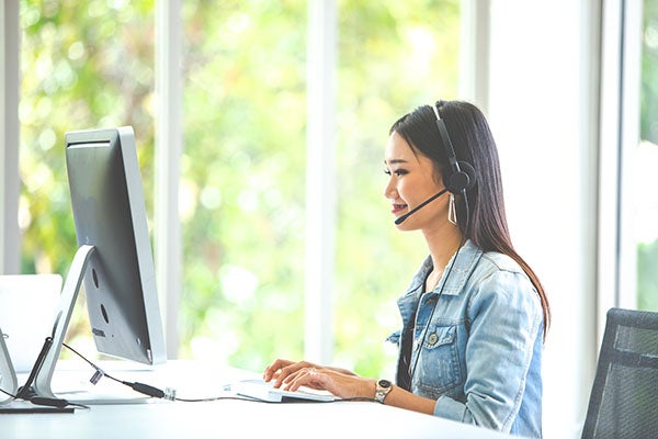 a woman with a headset sitting in front of a computer